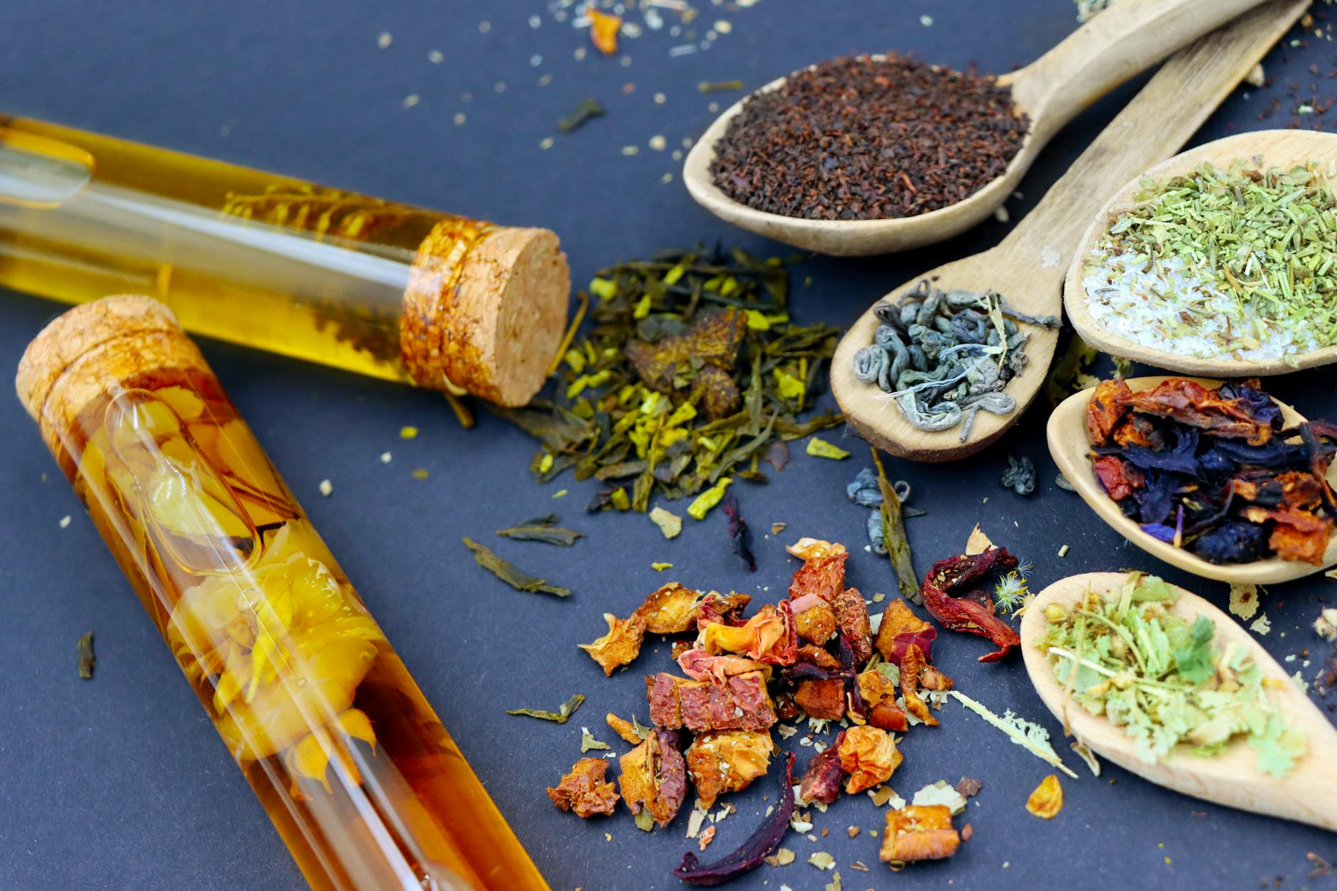 Side-by-side comparison of black tea and green tea leaves used in kombucha brewing with different caffeine levels