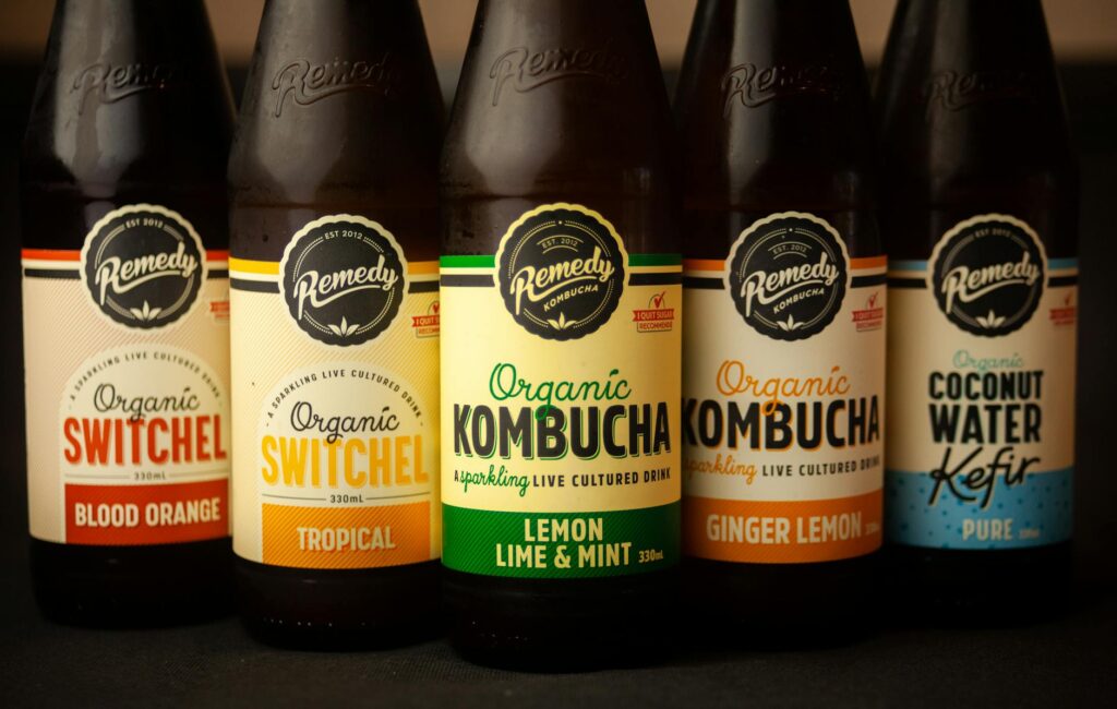 Side-by-side comparison of kombucha in glass bottle and kefir in jar showing fermented probiotic drinks