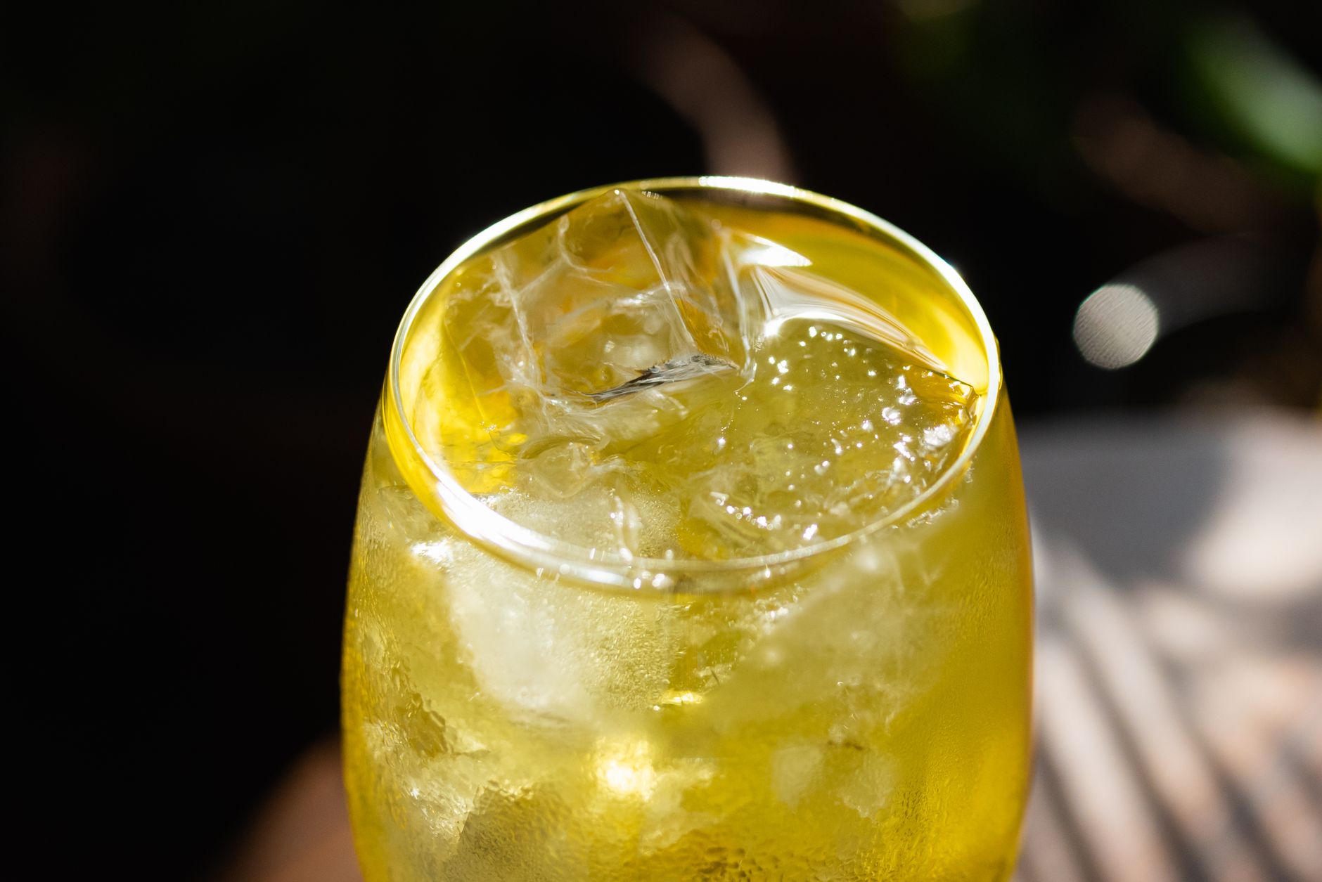 Close up of carbonation bubbles rising in a glass of kombucha, showing the fizz that can cause bloating before bed.