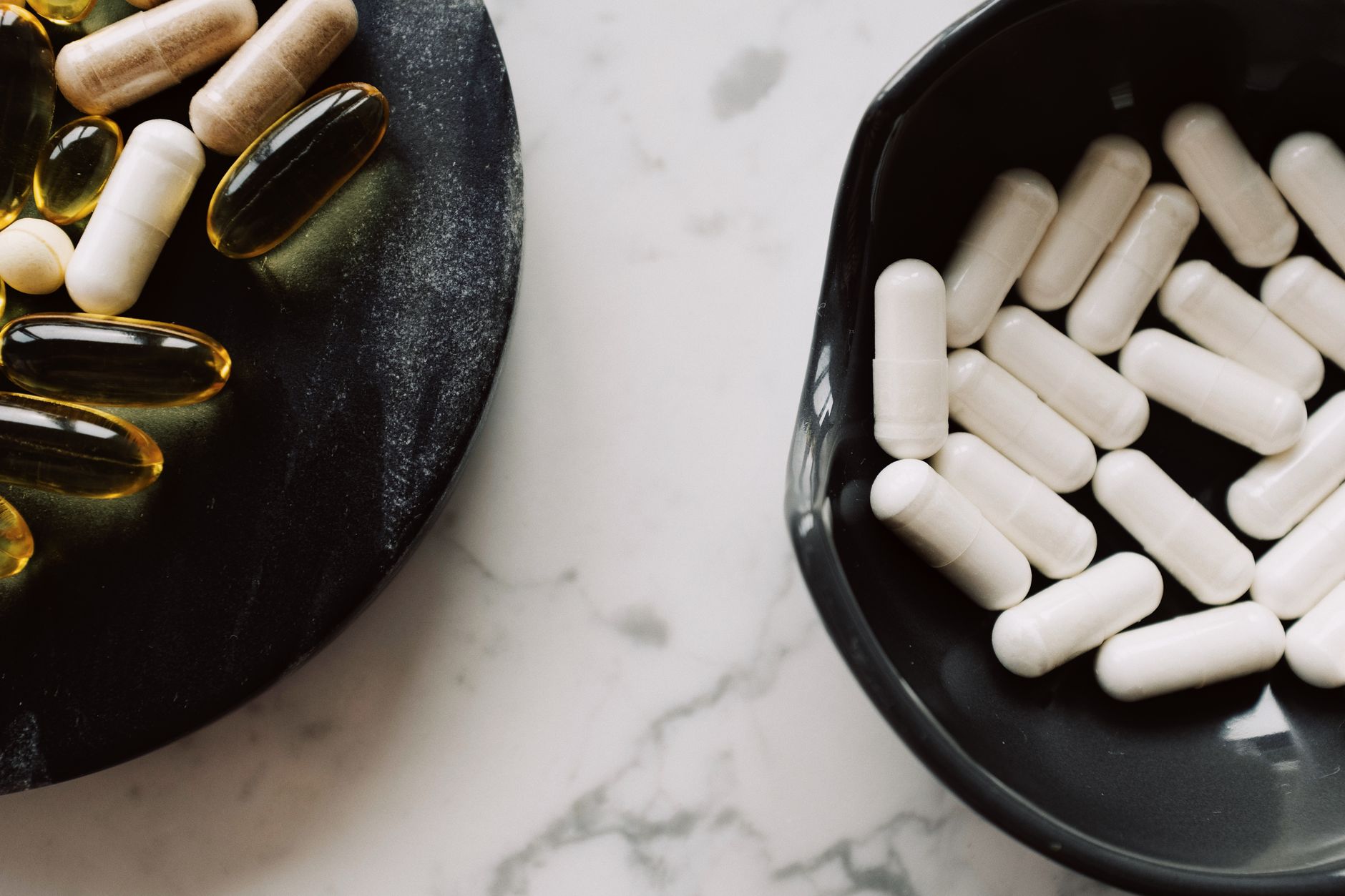 Probiotic supplements next to birth control pill pack on a white surface, illustrating the gut health and hormonal contraception topic.