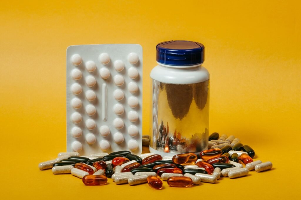 A glass of kombucha next to a daily pill organizer on a kitchen counter, representing diabetes management choices.