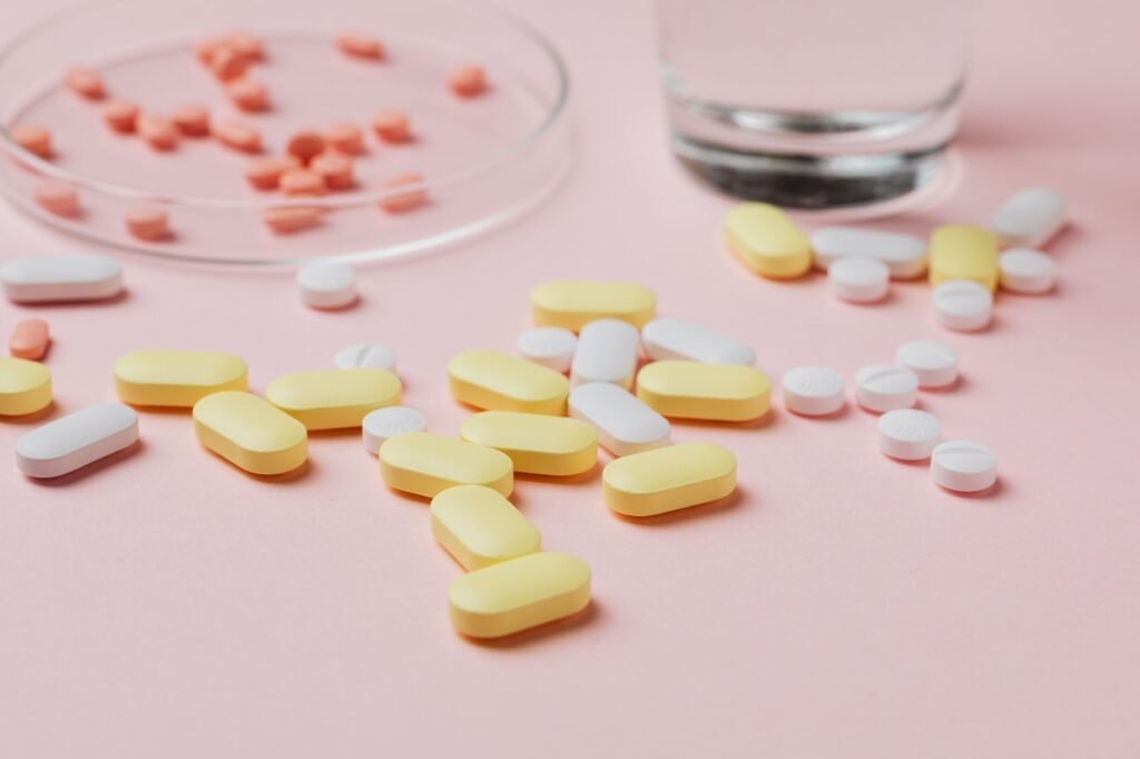 A glass jar of kombucha placed next to a prescription pill bottle on a kitchen counter