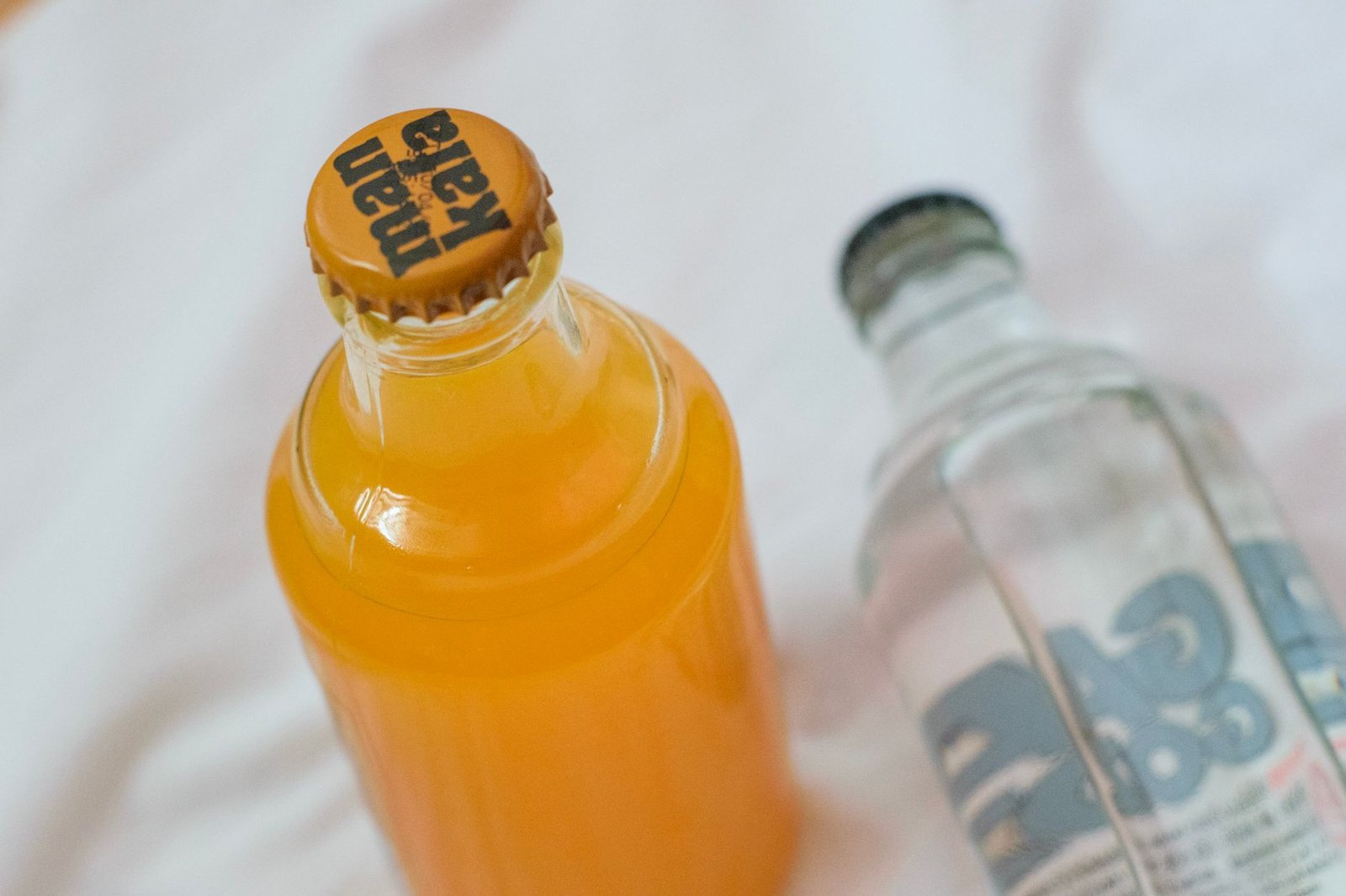 Kombucha being poured into a clear glass on a kitchen counter in natural daylight