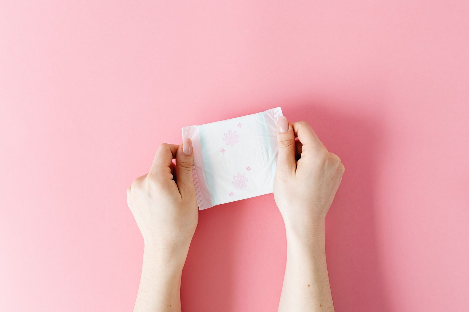 Person holding a heating pad against their abdomen suggesting bladder discomfort during a UTI