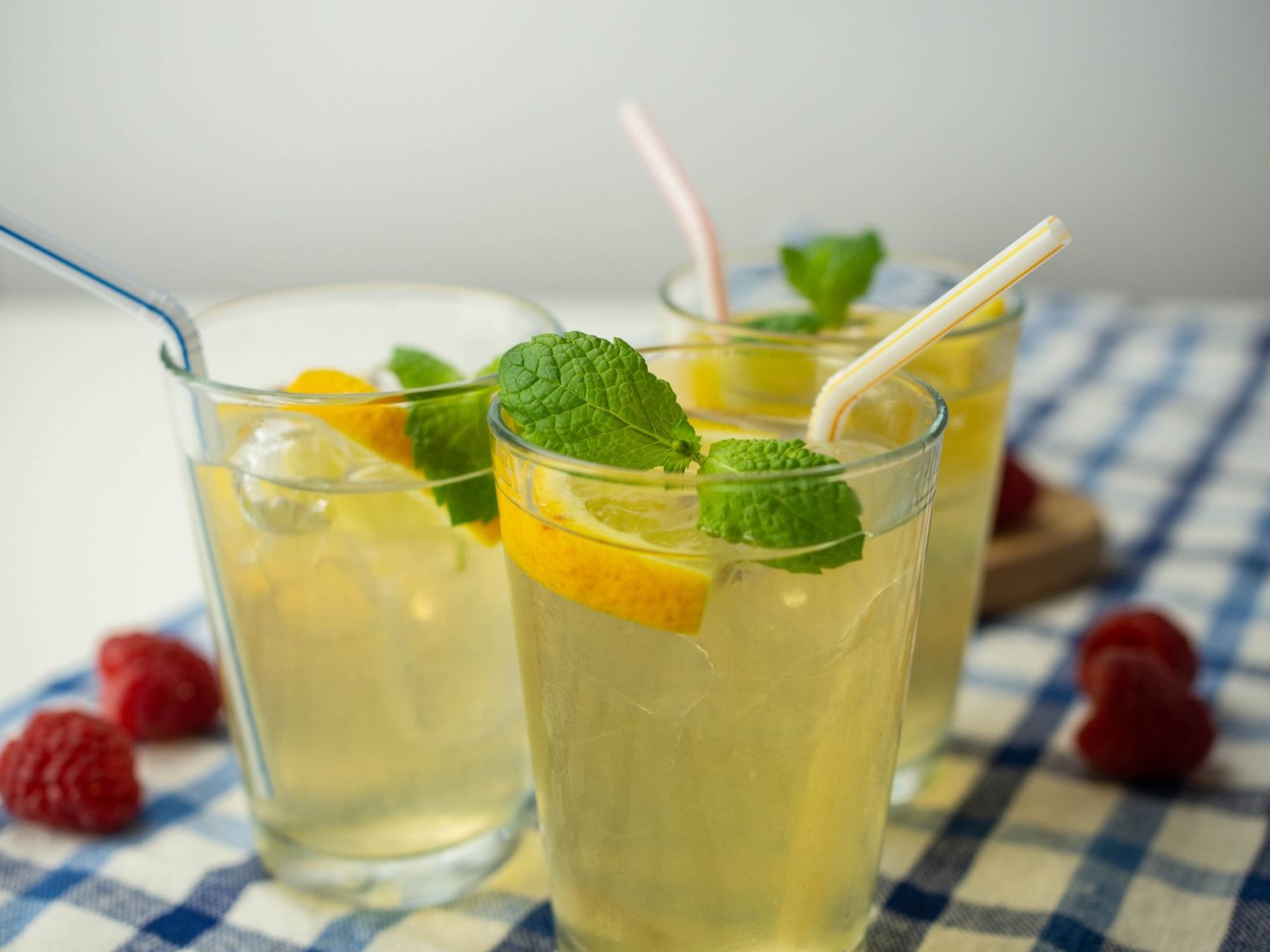 Person drinking kombucha through a straw to reduce acid contact with teeth